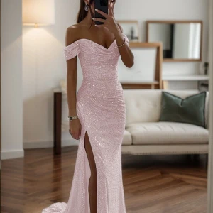 Ljusrosa glittrig långklänning med slits - Säljer en superfin ljusrosa långklänning med glittriga paljetter. Klänningen har offshoulder-modell, figurnära passform och en snygg slits framtill. Perfekt för bal eller fest! Materialet är syntet och paljetter för extra glamour. Aldrig använd, endast testad. Nypris 2000 kronor. 