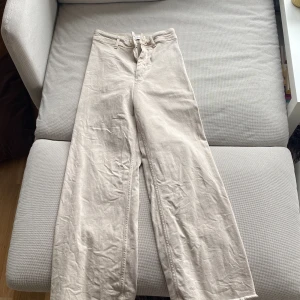 Beiga wide leg byxor från Zara - Säljer ett par beiga wide leg byxor från Zara med hög midja och stora bakfickor. Byxorna är i ett mjukt bomullsmaterial och har en klassisk look med raka, vida ben. Perfekta för en avslappnad och stilren outfit. (För små för mig)