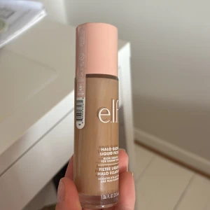 e.l.f. Halo Glow Liquid Filter Shade 3.5 Medium - OÖPPNAD e.l.f. Halo Glow Liquid Filter i nyansen 3.5 Medium. Flytande foundation med glow-effekt som ger en strålande finish. Kommer i en genomskinlig flaska med rosa lock. Perfekt för dig som vill ha lyster och jämn hudton.