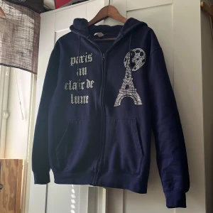 Zip hoodie från Blinglucid - Säljer en fet mörkblå zip hoodie från blinglucid, skicket är perfekt ingen defekt på den. Säljer för att jag växt ut den. Storlek M