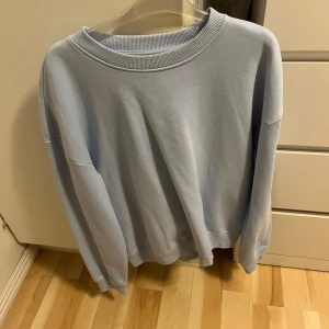 Ljusblå sweatshirt från 157 - Säljer en enkel och stilren ljusblå sweatshirt från 157 i storlek S. Tröjan har rund halsringning, långa ärmar och ribbade muddar vid ärmslut och nederkant. Perfekt för en avslappnad look.
