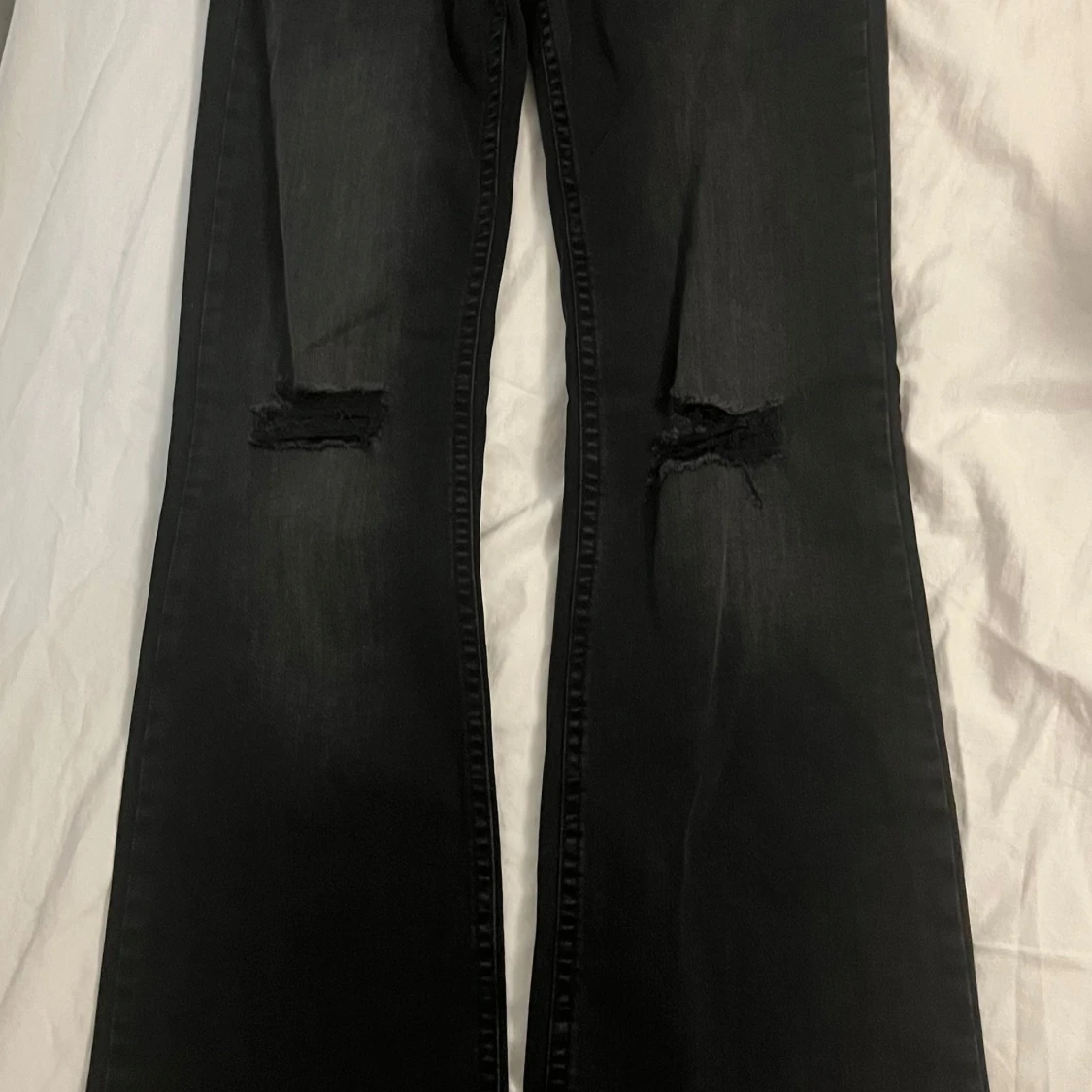 Svarta bootcut jeans med hål på knäna