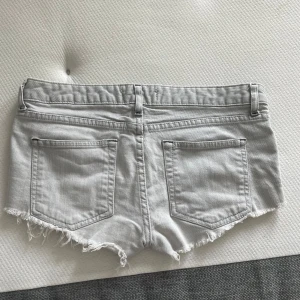 Ljusgrå jeansshorts😍 - Säljer ett par ljusgrå jeansshorts med en klassisk femficksdesign. Shortsen har bälteshällor och låg midja, perfekt för en avslappnad stil. 38cm midjemått rakt över💓