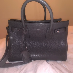 Saint Laurent Sac de Jour väska  - Väska från Affordable Luxury (15995:-), ordinarie köp från Nathalie Schuterman (finns kvitto från båda köp, samt äkthetsbevis och dustbag).      25,5 cm bred och 19 cm hög. Några små defekter. 