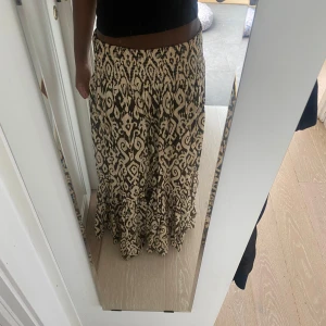 Mönstrad långkjol i svart och beige - Säljer en snygg långkjol med svart och beige mönster. 