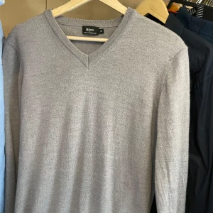 Grå stickad cashmere tröja - Säljer en stilren grå stickad tröja (cashmere) med v-ringning. Mjuk och skön känsla, klassisk modell med lång ärm.