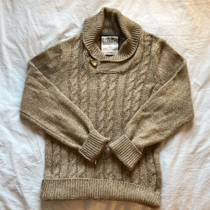 Beige stickad tröja från Glenwood - Säljer en beige stickad tröja från Glenwood med kabelstickat mönster och hög krage med knappdetalj. Tröjan har långa ärmar och ribbade muddar vid ärmslut och nederkant. Perfekt för kyliga dagar! Pris kan diskuteras!💕