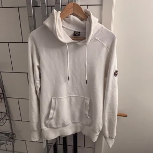 Colmar hoodie - Säljer en stilren vit hoodie från Colmar med huva. Tröjan har en klassisk känguruficka framtill och Colmar-logga på ärmen. Perfekt för en avslappnad och sportig look. Pris kan diskuteras