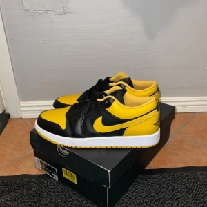 Jordan 1 Low ”Yellow Ochre” - Mycket bra skick, som nya. Använda bara 2 gånger. Dem är lite mörkare i verkligheten, hade blixten på för att visa dem mer detaljerat. Har inte kvar originalboxen eftersom dem var köpte utomlands dock så skickar jag dem i en annan liknande Jordan skokartong. Storlek 46. Pris:1000kr