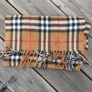Brun beige burberry halsduk - Burberry halsduk i fint skick förutom att den har ett hål 