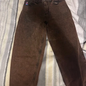 Polar Big Boy Jeans - Säljer ett par bruna jeansbyxor från Big Boy i storlek L. Byxorna har en klassisk femficksdesign och en broderad detalj vid fickan. De har en rak passform och är tillverkade i denim. Lite fläckar som går enkelt bort i tvätten men har en defekt som man kan sy om man vill som ni ser på bilden