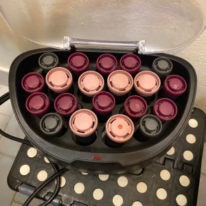 Värmespolar och klämmor i vinröd och rosa - Säljer ett set med värmespolar i vinröd och ljusrosa färg, samt tillhörande klämmor i matchande färger. Perfekt för att skapa volym och lockar i håret. Kommer i en svart värmebox med genomskinligt lock.