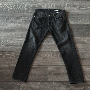  Replay Grover - Säljer ett par svarta Replay Grover jeans med straight fit. Klassisk femficksmodell med diskret broderad logga på bakfickan. Jeansen har normal passform och är tillverkade i ett slitstarkt denimtyg. Byxorna e inte använda många gånger. Och har inga defekter för utom en på bakfickan.