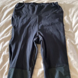 Svarta träningstights med ficka - Svarta tights perfekta för träning, med hög midja och praktisk ficka på benet. Materialet är stretchigt och bekvämt, vilket ger bra rörelsefrihet. Passar dig som vill ha funktionella och stilrena tights till gymmet eller löprundan. ca 60 cm i benen 