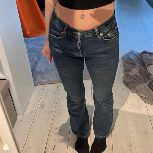 Mörkblå jeansbyxor med bootcut - Säljer ett par mörkblå jeansbyxor med klassisk femficksdesign och bootcut-stil. Byxorna har låg midja och raka ben som blir lite utsvängda nertill. De är i stl 34, (petite)