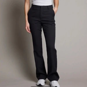 Vilma kostymbyxor från BikBok - Snygga svarta kostymbyxor från BikBok med hög midja och raka ben. Byxorna har klassisk design med diskret dragkedja och knapp framtill. Supersköna och sparsamt använda! Dessa är små i storleken! 