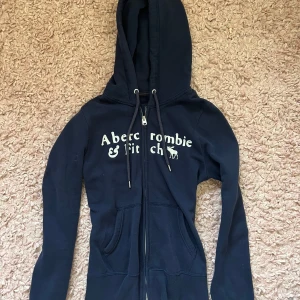Abrecrombie and fitch zip up - Marin blå abrecrombie and fitch zip up i storlek s.  Ganska 2000s vibe. Inga defekter. Använd 2 gånger. Tryck gärna på ”köp nu”. Öppen för prisförslag. Det är bara att skriva om du har någon eller några frågor