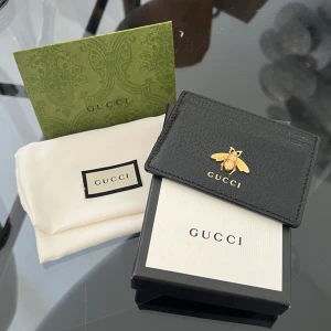 Svart korthållare från Gucci med guldbi - Säljer en helt oanvänd stilren svart korthållare från Gucci i skinn. Perfekt för kort och enkel att ta med sig. Kommer med originalask, dustbag och certifikat. 