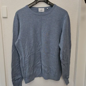 Ljusblå stickad tröja från Bläck - En enkel och stilren ljusblå stickad tröja från Bläck, Tröjan har rund halsringning och långa ärmar. Perfekt för lager-på-lager och passar till många olika outfits.