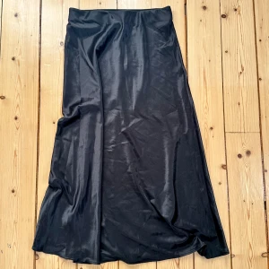 Sidenkjol - En svart sidenkjol med resor i midjan. Den är i S/M men skulle säga att den är med XS/S. 