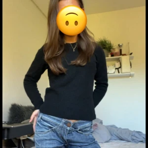 Svart ulltröja med rund hals - En klassisk svart långärmad tröja i ullblandning med rund halsringning. Tröjan är enkel och stilren, perfekt att matcha med jeans eller kjol. Materialet består av 50% ull vilket gör den både varm och mjuk. Från uniqlo i storlek xs