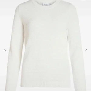Vit stickad tröja från VILA - Säljer en klassisk vit stickad tröja från VILA. Tröjan har rund halsringning, lång ärm och ribbade muddar vid ärmslut och nederkant. Perfekt att matcha med jeans eller kjol för en enkel och stilren look.