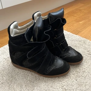Svarta sneakers med kilklack från Isabel Marant - Säljer mina svarta Isabel Marant bekett sneakers. Skorna har kardborreband, detaljer i ormskinnsmönster, kilklack och hög vadderad plös. Använda några gånger pris går att diskutera 💞
