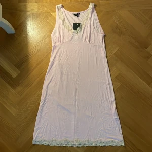 Ljusrosa nattlinne med spets från Twilfit - Säljer en ljusrosa nattlinne från Twilfit med fina spetsdetaljer vid halsringning och nederkant. 