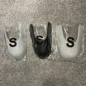 Skoinlägg för att skydda skorna, crease skydd.  - Säljer tre skoinlägg i plast, två vita och en svart. Perfekta för att hålla formen på dina sneakers eller boots och undvika att skona går sönder. Kommer i storlek S och passar till storlek 36-38. 