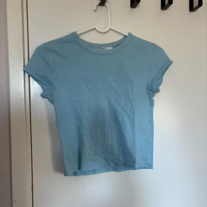 Ljusblå croppad t-shirt - En enkel ljusblå croppad t-shirt som är lätt att matcha med jeans eller kjol. 