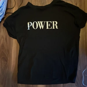 T-shirt med texten ”POWER” - Säljer en svart t-shirt i storlek M. T-shirten har texten ”POWER” tryckt på framsidan. Materialet är 100% bomull. 