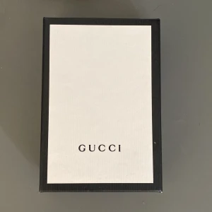 Svart korthållare från Gucci med guldbi - Säljer en svart korthållare från Gucci i skinn med en snygg guldfärgad bi-detalj framtill och Gucci-logga. Kommer med originalask och dustbag. Den är köpt i Melbourne, Australien på en Gucci butik och alltså äkta. Priset kan diskuteras! Var inte rädd att ställa frågor :) 