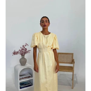 Ljusgul klänning med puffärmar - Säljer en ljusgul klänning med puffiga kortärmar och rund halsringning. Klänningen har en markerad midja och är tillverkad i ett glansigt material som ger en elegant känsla. Perfekt för sommarens tillfällen. Har bild på paketet men då den inte riktigt passade mig kan jag inte få några bilder när jag bär den! Den är jättefin verkligen! 