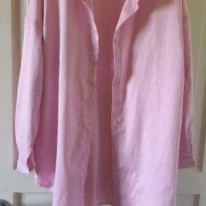 Ljusrosa skjorta från SHEIN - Säljer en ljusrosa skjorta från SHEIN i storlek L. Skjortan har klassisk krage, knäppning framtill och långa ärmar. Perfekt att styla både öppen och stängd för en chill look.