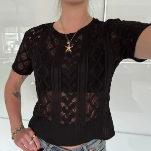 Svart spets t-shirt - En svart t-shirt i spets med mönster. Blusen har rund halsringning och är lätt transparent, perfekt att styla med olika accessoarer!✨(står att den är L men jag bär alltid S eller XS o den passar perfekt för mig)