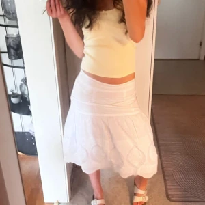 Långkjol vit  - Säljer en vit kjol från Soya Concept med broderade detaljer och lätt volang nertill. Kjolen har en feminin och luftig känsla, perfekt för varmare dagar. Tillverkad i bomull och har en normal passform.