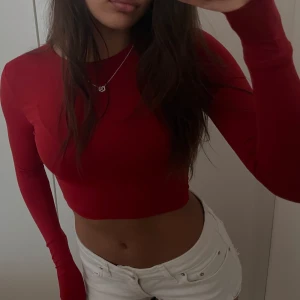 Röd croppad långärmad topp i polyamid - Croppad och långärmad topp med tight passform i polyamid. En snygg baströja i skönt material ❤️(XS-S)