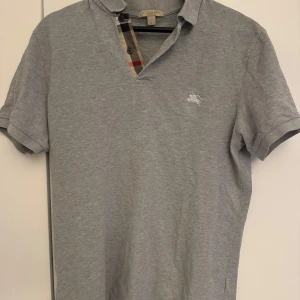 Grå Burberry piké  - Skick:8/10 storlek:Medium Äkthetscertifikat medföljer! Inga hål fläckar osv bara i allmänt fint skick 