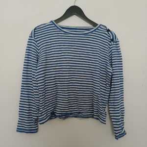 Blåvit randig långärmad tröja - Säljer en blåvit randig långärmad tröja från Whyred i mjuk bomull. Tröjan har klassisk rund halsringning och raka ärmar. Perfekt för en avslappnad stil och enkel att matcha med jeans eller kjol.