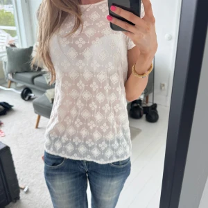 Vit spetsblus från Zara  - Säljer en söt vit blus från Zara Trafaluc med korta ärmar och genombrutet spetsmönster. Blusen har rund halsringning och ett diskret blommigt mönster i spetsen. Perfekt att styla med jeans eller kjol.💓🫶Passar S-M