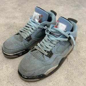 Nike Air Jordan 4 Retro University Blue - Säljer ett par Nike Air Jordan 4 Retro University Blue sneakers. Skorna är ljusblå med svarta och grå detaljer, meshpaneler och klassisk Jumpman-logga på hälen och sulan. De har snörning och en platt sula för en sportig look. Ganska smutsiga men är säker på att de går att renas och gjorde inte så bra jobb på loose lacen men de går att ändras lätt😅.