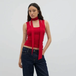 Röd ärmlös topp med scarfdetalj - Trendig röd ärmlös topp. Toppens material är mjukt och stretchigt, perfekt för en stilren look. Rund halsringning och figurnära passform.