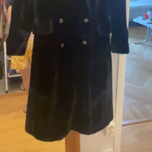 Svart pälsjacka med dubbelknäppning  - Säljer en klassisk svart pälsjacka med bred krage och dubbelknäppning framtill. Jackan har en elegant och tidlös design, perfekt för kyliga dagar. Fodrad insida för extra komfort. / priset kan diskuteras