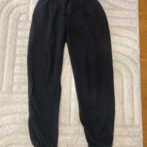 Svarta mjukisbyxor med resår - Svarta mjukisbyxor med resår i midjan och vid bensluten. Byxorna har en avslappnad passform och är perfekta för en chill vardagslook. Tillverkade i mjukt material som känns skönt mot huden.