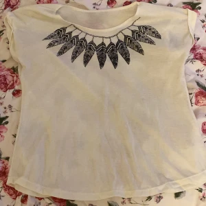 vit t-shirt med svart fjädermönster - jätte söt 2014 tumblr fjädertröja. köpte den från en thrift store under sommaren men den passar tyvärr inte mig som jag vill. har inga defekter men den kan vara lite urtvättad kanske. ingen storlek står men jag skulle säga att den är S-M. skriv om du vill diskutera priset