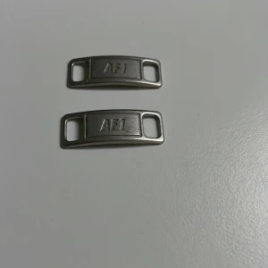 AF1 snörningsdetaljer i metall - Två stycken metalltaggar med 'AF1'-text, perfekta som snörningsdetaljer till Nike Air Force 1 sneakers. Ger dina skor en clean och klassisk look. Pris kan diskuteras 