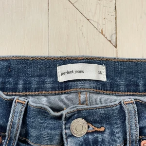 Blå bootcut jeans från Perfect Jeans - Säljer ett par klassiska blå bootcut jeans från Gina tricot Perfect Jeans. Jeansen har normal passform upptill och utsvängda ben, med snygga kontrastsömmar och femficksdesign. Perfekta till sneakers eller boots.