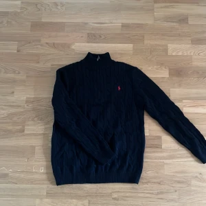 quarter zip Polo Ralph Lauren - Svart kabelstickad tröja från Polo Ralph Lauren| med halv dragkedja och hög krage. I princip helt ny endast testad, Skriv vid funderingar PRISET ÄR EJ HUGGET I STEN 