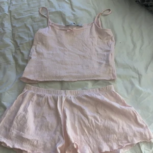 Ljusrosa linnetopp med shorts från 157 - Säljer ett ljusrosa set från 157 med en tunn linnetopp med smala axelband och matchande shorts. Perfekt för varma dagar eller som mysigt set hemma. Materialet är mjukt och luftigt.