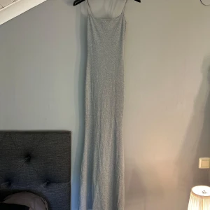 Grå långklänning från Design by Si - Säljer en enkel och stilren grå långklänning från Design by Si. Klänningen har smala axelband och är figurnära med rak passform. Oanvänd!💞
